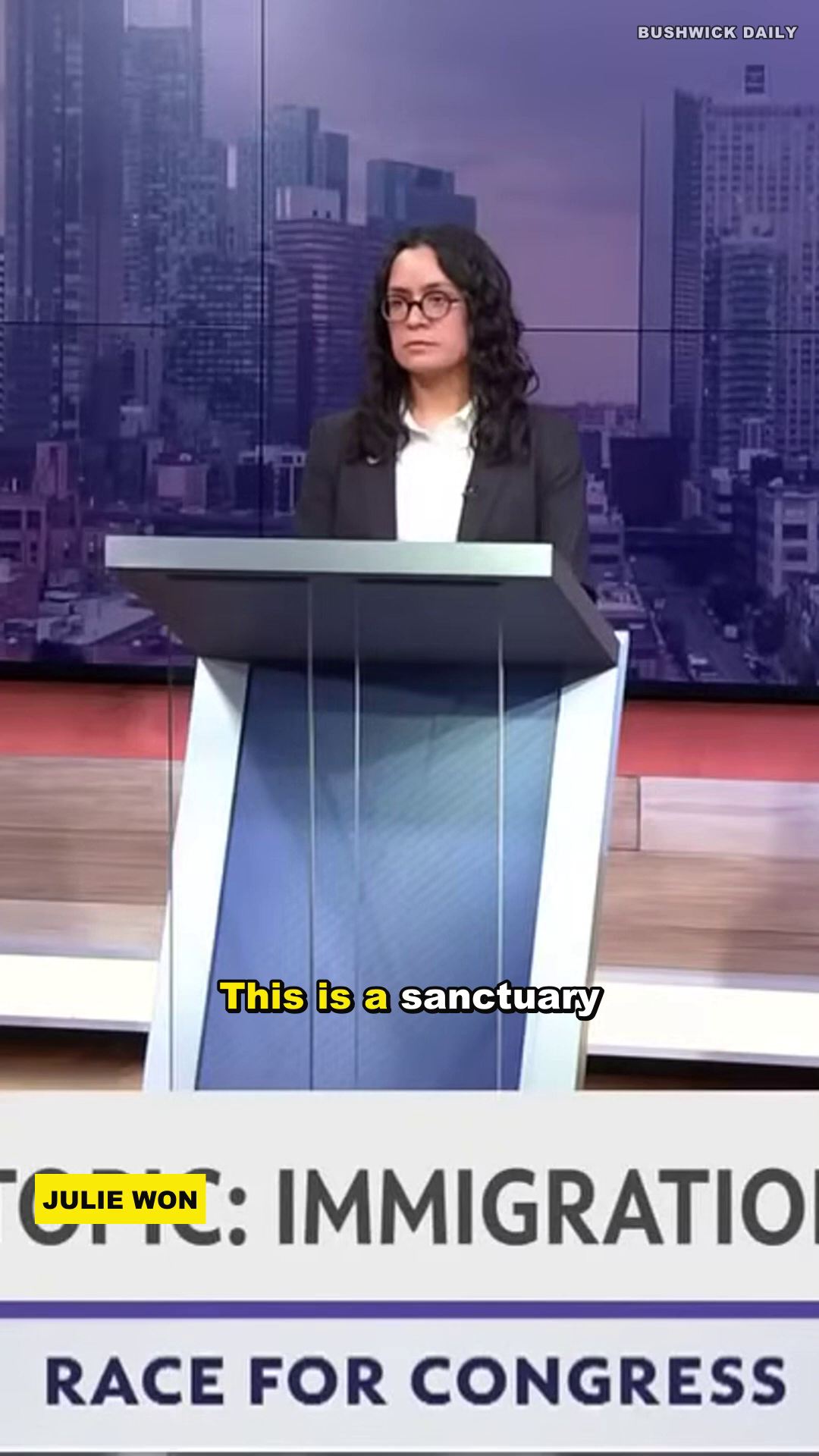 A second finished 9:16 render frame: JULIE WON lower-third, IMMIGRATION topic banner, karaoke caption — proving the $0 render looks broadcast-grade and tracks identity across a multi-speaker debate.